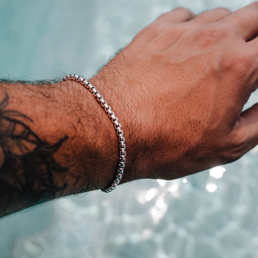 Silver Round Box Bracelet on man's hand above water