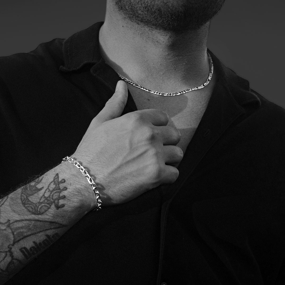 Man wearing a silver necklace and bracelet in black and white