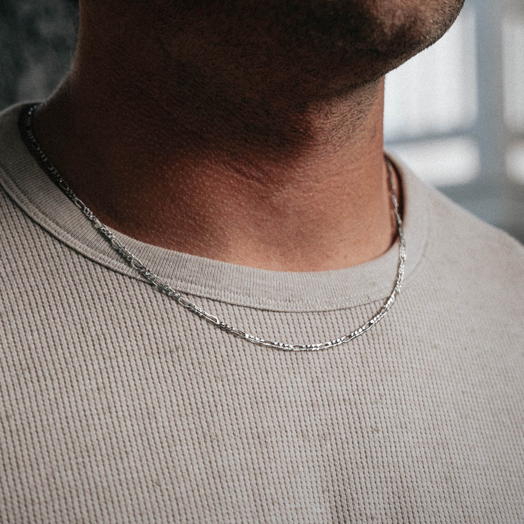 Man wearing sterling silver 3mm Figaro chain necklace. Size: 20"