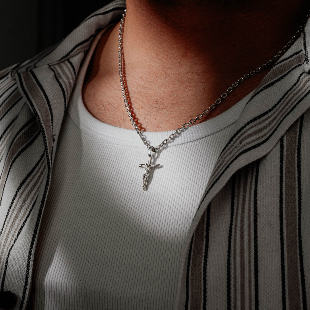 Silver crucifix pendant necklace worn by a man with a white shirt. Size: 3.5mm (22")