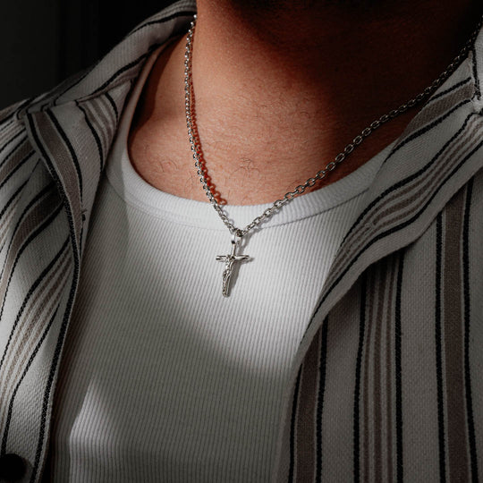 Silver crucifix pendant necklace worn by a man with a white shirt. Size: 3.5mm (22")