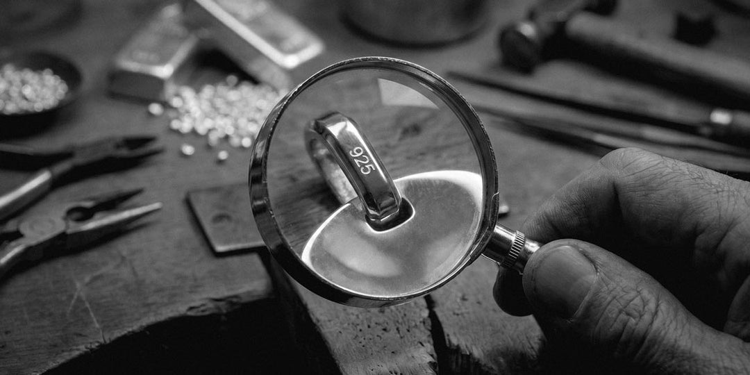 Italian goldsmith using a magnifying glass to inspect the 925 stamp on the pendant